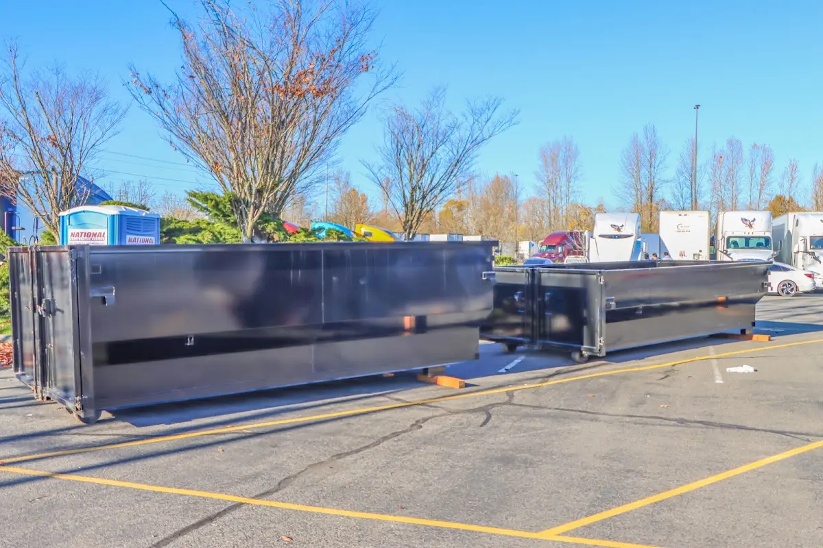 Professional dumpster rental service with roll-off container on residential driveway in Pitman